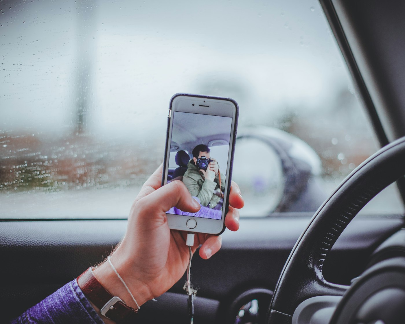 Téléphone tenu à proximité du volant dans une voiture