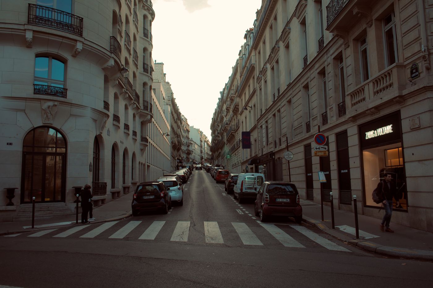 Voitures stationnées en créneau le long d’une rue parisienne